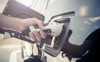 Person plugging a charger into an electric vehicle.