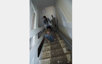 Family standing on a bare staircase, displayed at the 'Cold Realities' exhibition.
