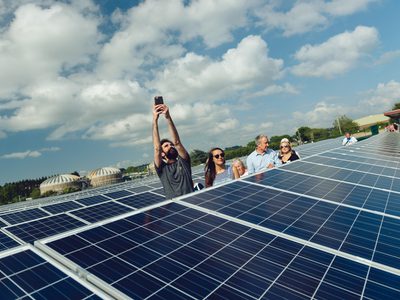 Individuals at PEC’s Ernesettle solar farm with solar panels in view.