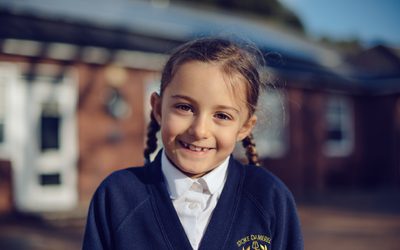 Child smiling in a school uniform.