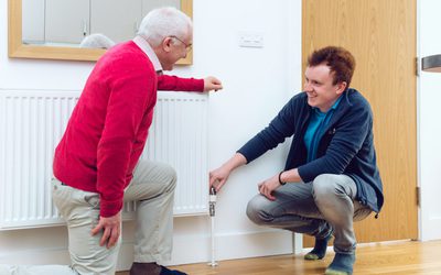 Energy advisor showing a client how to adjust a radiator during a home visit.